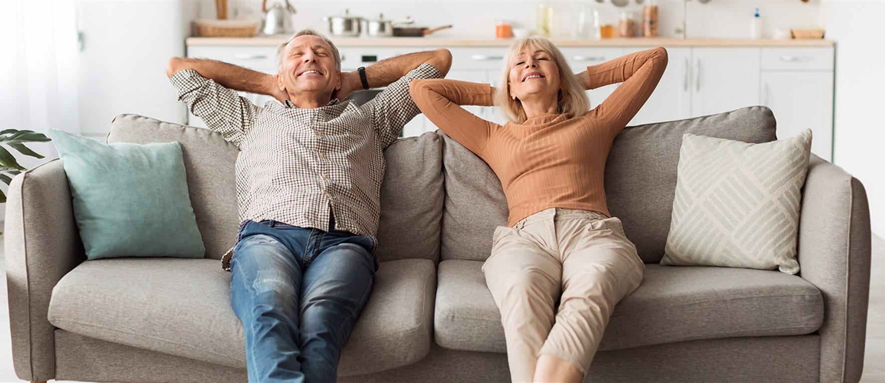Due persone anziane sedute rilassate sul divano in soggiorno. Due persone anziane sedute rilassate sul divano in soggiorno.