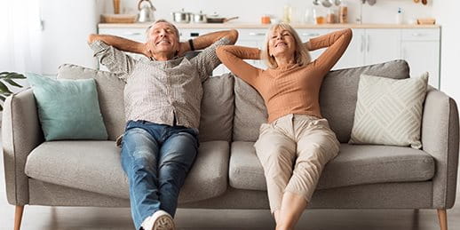 Due persone anziane sedute rilassate sul divano in soggiorno. Due persone anziane sedute rilassate sul divano in soggiorno.