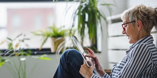 Une femme est assise par terre avec une tablette