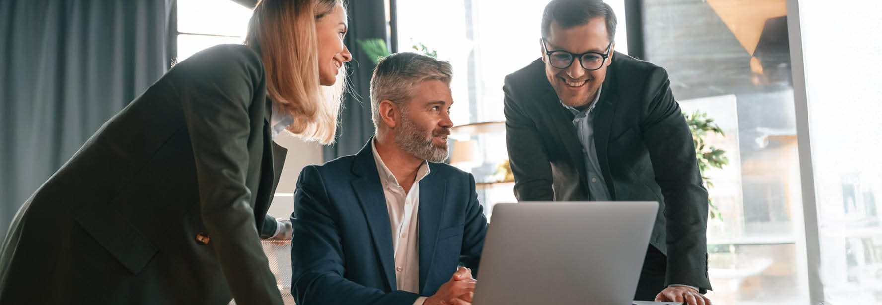 Tre persone che guardano in un computer portatile