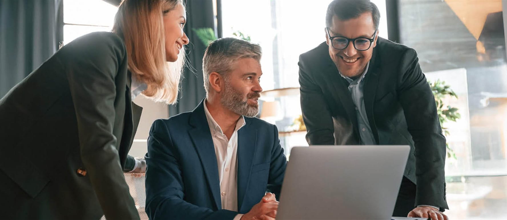 Tre persone che guardano in un computer portatile Tre persone che guardano in un computer portatile