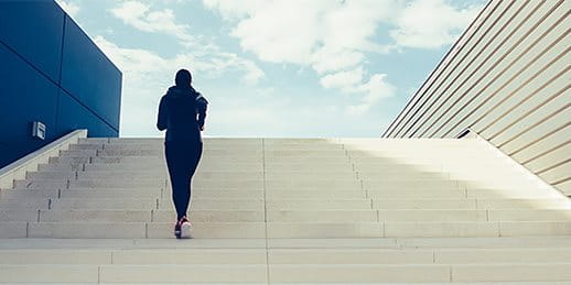 Une femme monte les escaliers d'un pas vif