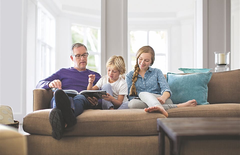 Father is sitting on the sofa with his children Father is sitting on the sofa with his children