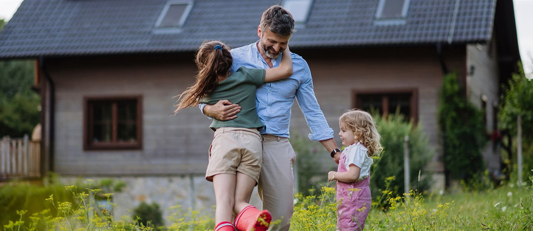 Un père joue avec ses enfants dans la prairie Un père joue avec ses enfants dans la prairie