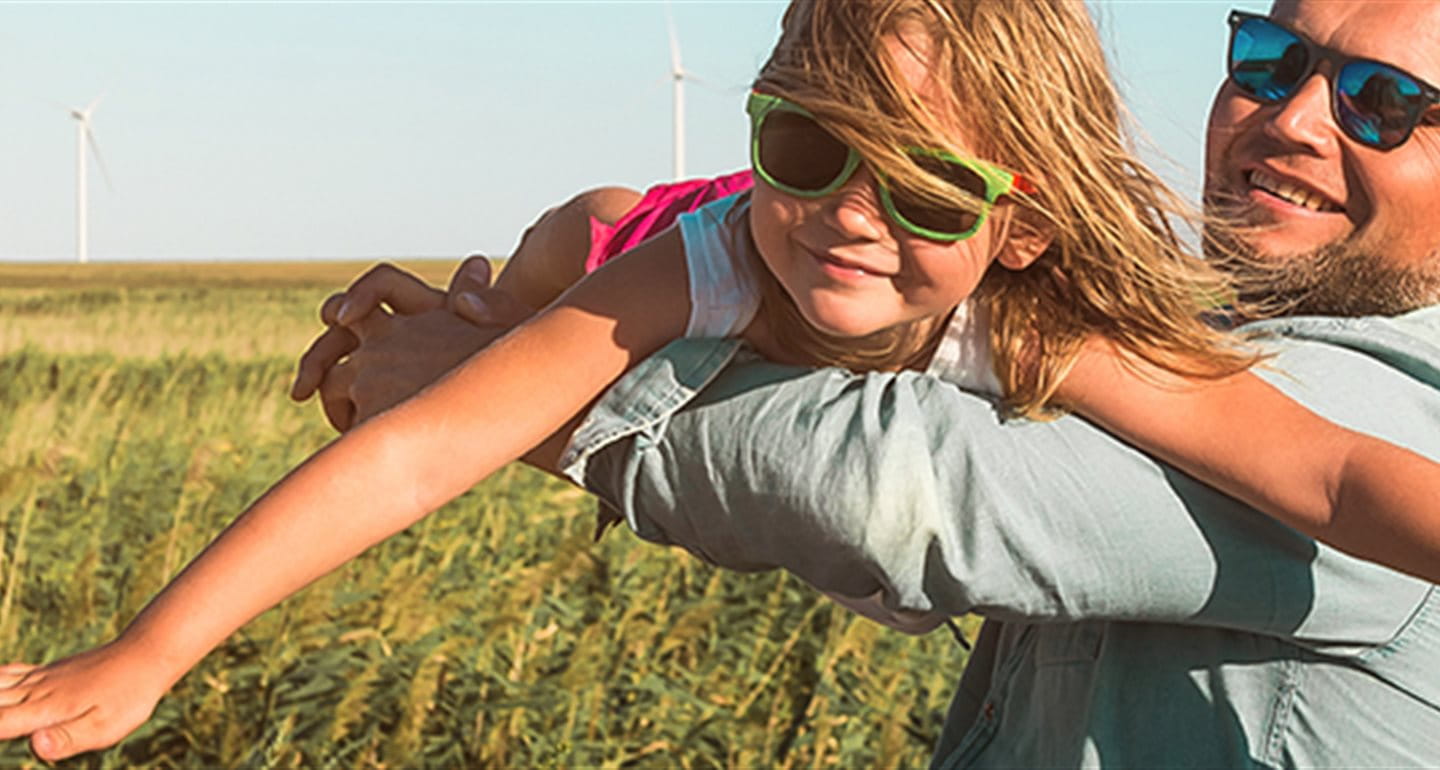 Man with child in a field in front of wind turbines Man with child in a field in front of wind turbines