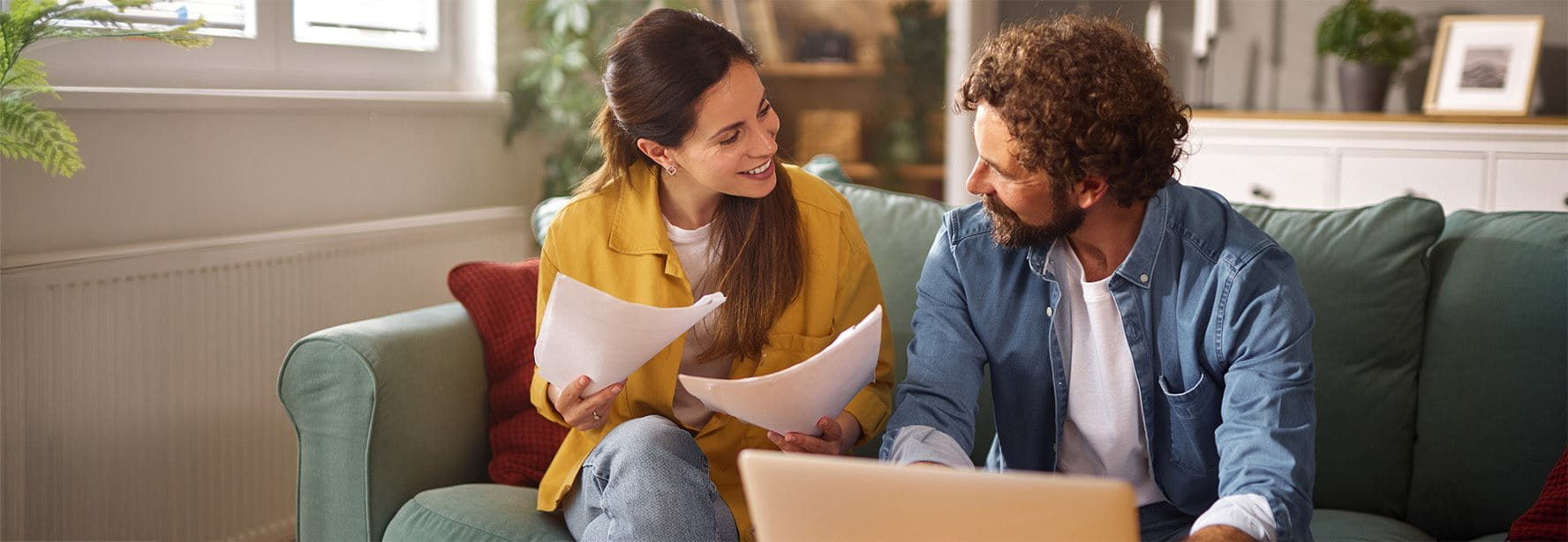Una coppia è seduta su un divano e discute dei documenti