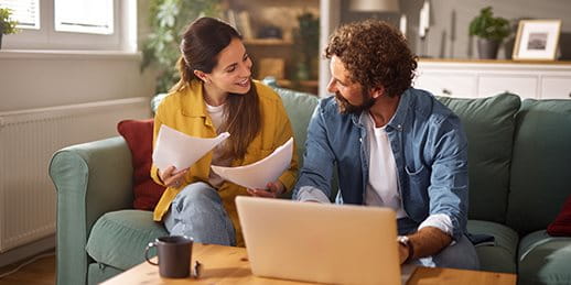 Una coppia è seduta su un divano e discute dei documenti