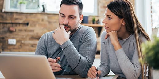 Paar sitzt vor dem Laptop und denken nach Paar sitzt vor dem Laptop und denken nach