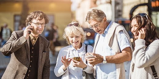 Zwei Paare sind am Telefon in einer Stadt unterwegs