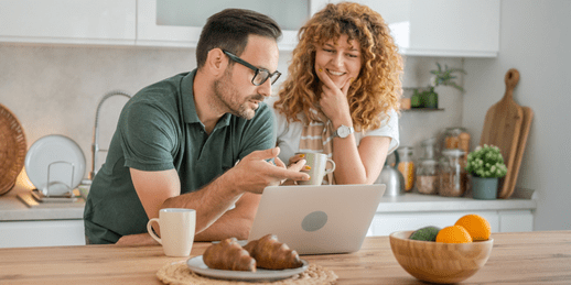 Couple dans la cuisine, regardant un ordinateur portable