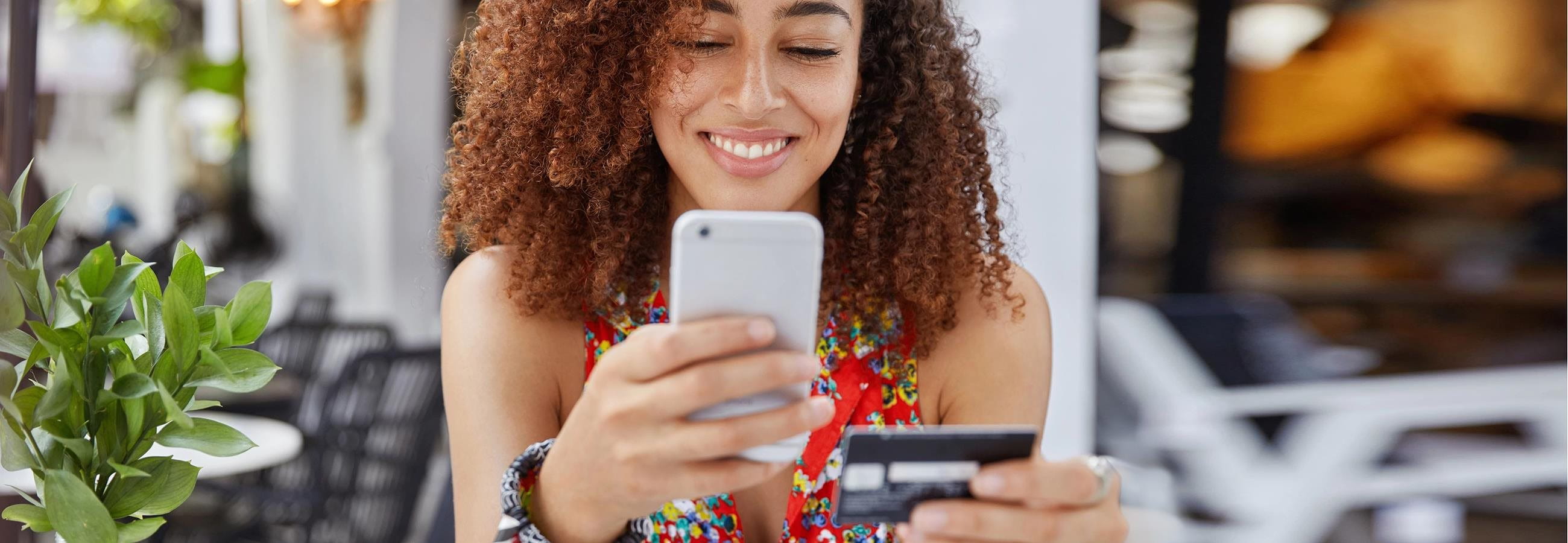 Woman is on cell phone and holding credit card