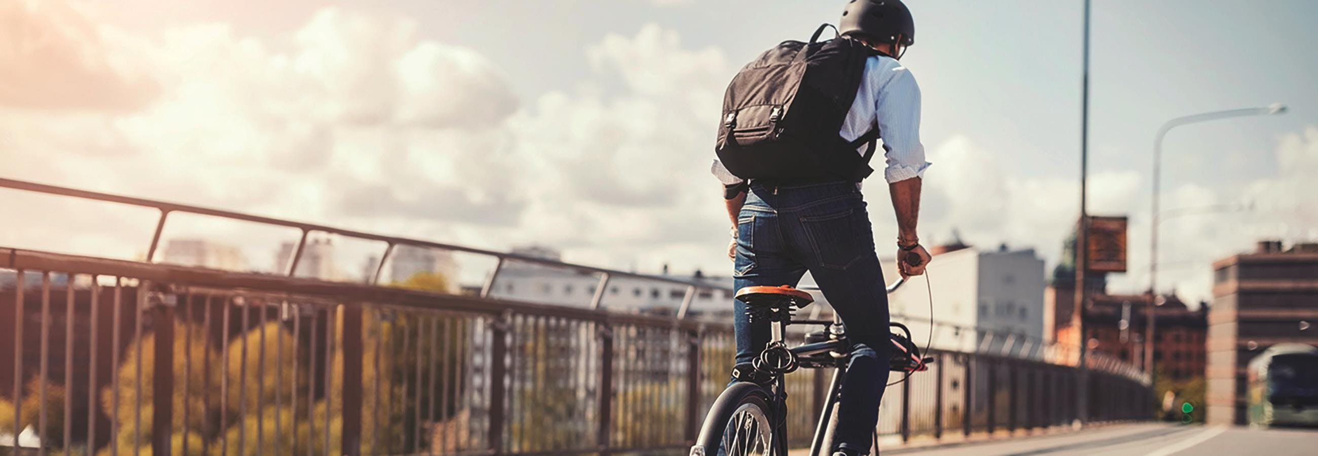 Mann fährt auf einem Fahrrad über eine Brücke
