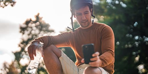 Skater is looking at his smartphone.