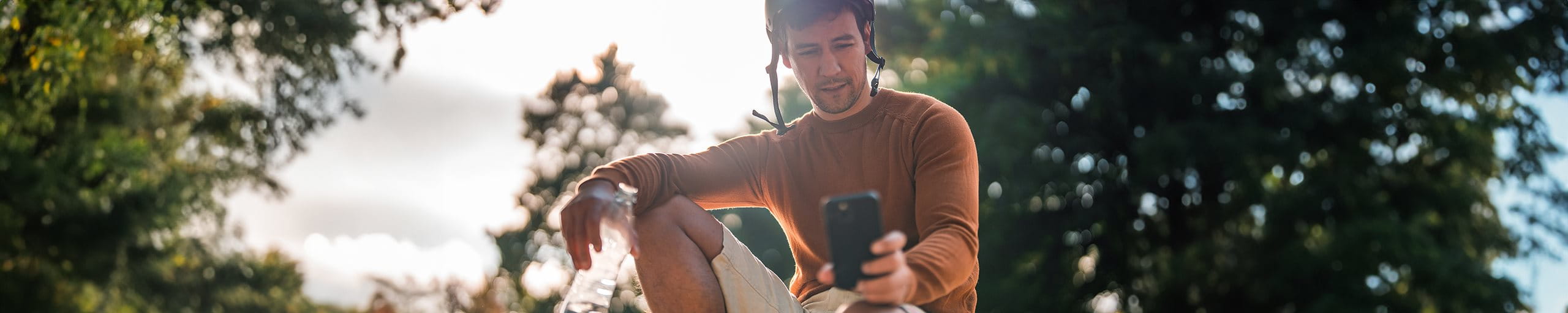 Skater schaut auf sein Smartphone