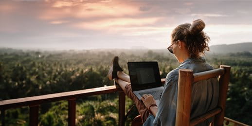 A woman is working with a laptop on the terrace