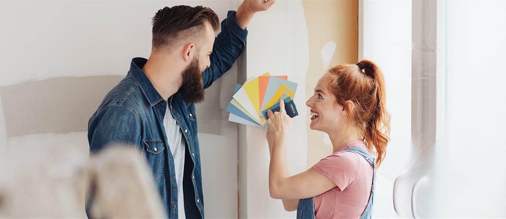 Zwei Personen wählen Farbmuster beim Renovieren. Zwei Personen wählen Farbmuster beim Renovieren.