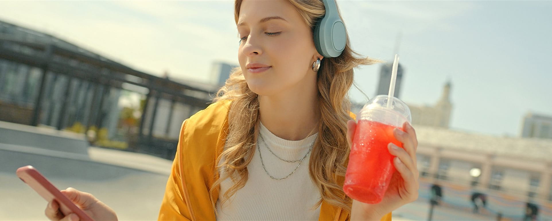 Une jeune fille écoute de la musique avec des écouteurs et tient un icetea. Une jeune fille écoute de la musique avec des écouteurs et tient un icetea.