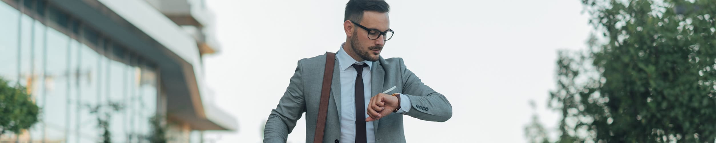 Mann schaut auf seine Armbanduhr