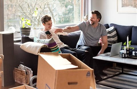 Freunde ruhen sich auf Sofa aus und Zügelkartons stehen rum Freunde ruhen sich auf Sofa aus und Zügelkartons stehen rum