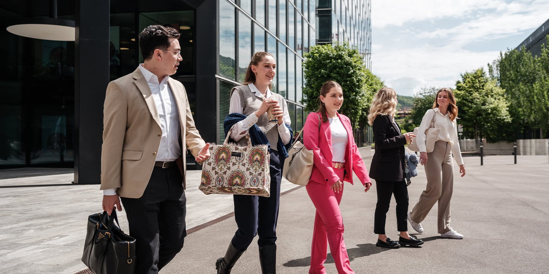 Vier junge Menschen laufen aus einem Gebäude.