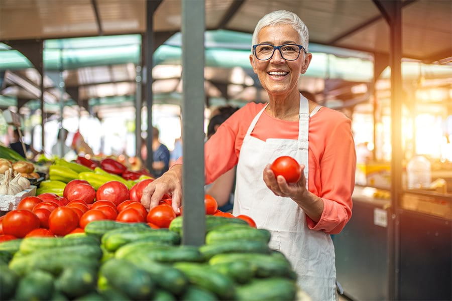 Une femme devant des légumes frais.
