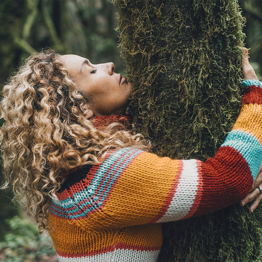 Woman hugs a tree.