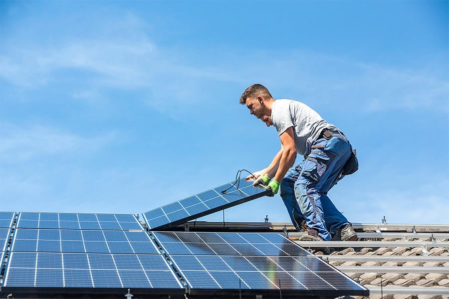 Homme monte un panneau solaire