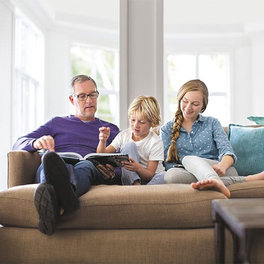 A man reading a book with two children