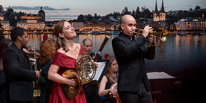 Concert en plein air avec des musiciens devant un lac et une ville. Concert en plein air avec des musiciens devant un lac et une ville.