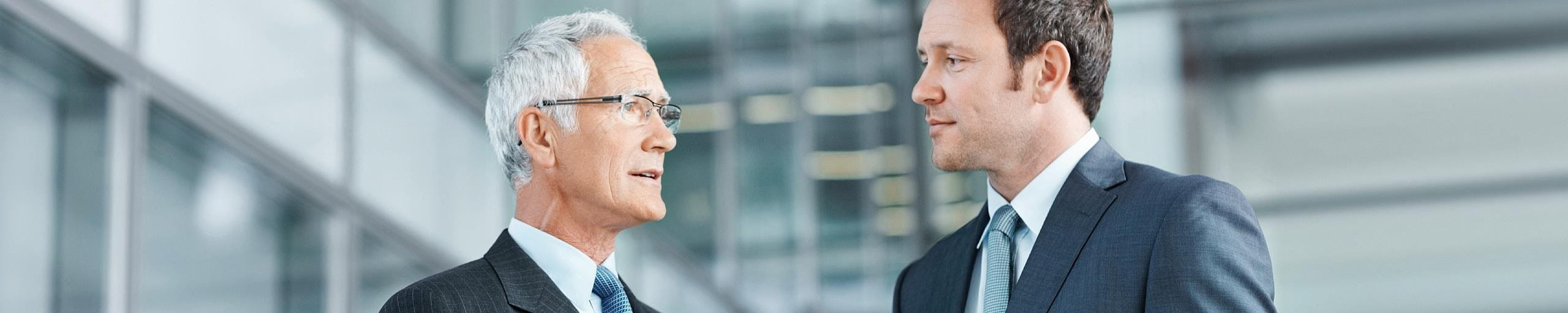 Deux hommes s'entretiennent dans la cour intérieure d'un bâtiment.