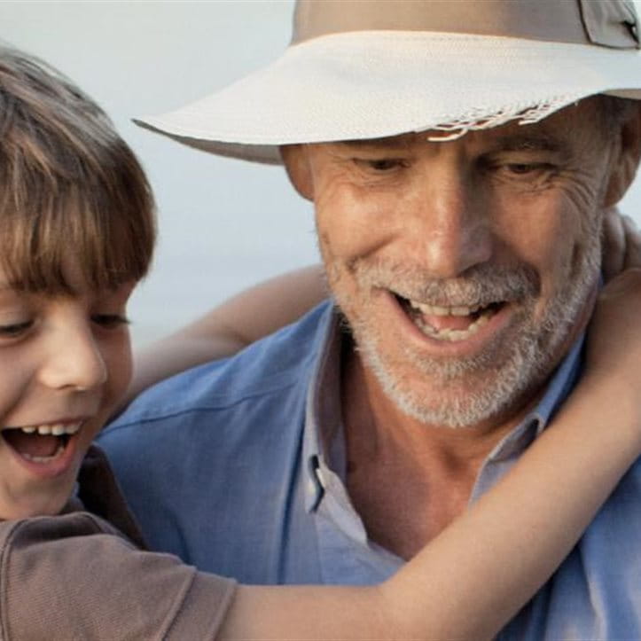 A boy in the arms of an elderly man. A boy in the arms of an elderly man.